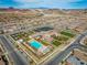 Stunning aerial view of community amenities, pool, clubhouse, tennis courts, and surrounding neighborhood in a desert landscape at 732 Rosewater Dr, Henderson, NV 89011