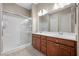 Bathroom featuring double sinks, a large mirror, and a tiled glass shower at 732 Rosewater Dr, Henderson, NV 89011