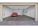 A clean, open garage with epoxy flooring and a red convertible parked inside at 732 Rosewater Dr, Henderson, NV 89011