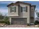 Two-story home featuring stone accents, a front-entry garage, and a welcoming covered porch at 9070 Rivington Ave, Las Vegas, NV 89148