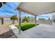 Charming backyard with manicured grass, stone, and a covered patio at 9264 Ansley Ct, Las Vegas, NV 89148