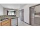 Practical kitchen with stone countertops, stainless sink and dishwasher, and a laundry room at 9264 Ansley Ct, Las Vegas, NV 89148