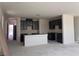 A new kitchen with dark cabinets, a white island, and an open floor plan at 9989 River Corral St, Las Vegas, NV 89166