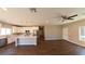 Open concept kitchen and living area with hardwood floors, white cabinetry, and stainless steel appliances at 1931 Rose Ct, Pahrump, NV 89048