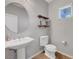 Cozy half-bathroom featuring decorative shelves, a round mirror and a pedestal sink at 2641 Vendange Pl, Henderson, NV 89044