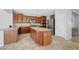 Charming kitchen featuring wood cabinetry, an island and stainless steel appliances at 2641 Vendange Pl, Henderson, NV 89044