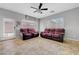 Comfortable living room featuring tile flooring, two sofas, and a ceiling fan at 2641 Vendange Pl, Henderson, NV 89044
