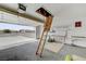 Open garage featuring an attic access ladder, overhead door opener, and workbench at 3581 Pahrump Valley Blvd, Pahrump, NV 89048