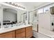 Well-lit bathroom with double sinks, a tub, and a sliding glass door shower at 436 Pumpkin Way, Henderson, NV 89015