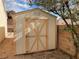 Backyard storage shed with beige walls and decorative trim at 436 Pumpkin Way, Henderson, NV 89015