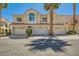 Charming two-story townhome with a two-car garage and tile roof, nestled between palm trees at 5412 Harmony Green Dr # 101, Las Vegas, NV 89149