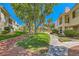 Beautiful condo complex with mature trees and a lush green lawn, offering serene outdoor living at 5412 Harmony Green Dr # 101, Las Vegas, NV 89149