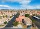 Aerial view of a community with multi-colored houses, palm trees, well-kept lawns, and mountain views at 6790 Gold Yarrow St, Las Vegas, NV 89148