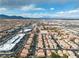 Expansive aerial view of a vibrant community with mountain views in the distance under a partly cloudy sky at 6790 Gold Yarrow St, Las Vegas, NV 89148
