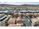 Aerial view showcasing a residential area with colorful houses, commercial properties and mountain views in the distance at 6790 Gold Yarrow St, Las Vegas, NV 89148