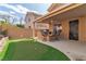 Backyard featuring a covered patio with bar seating, a built-in grill, and a well-manicured artificial turf at 6790 Gold Yarrow St, Las Vegas, NV 89148
