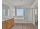 Charming bathroom features a dual sink vanity with wood cabinets, a soaking tub, and a glass-enclosed shower at 6790 Gold Yarrow St, Las Vegas, NV 89148