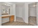 Light-filled bathroom features a wood vanity with a large mirror and adjoins a walk-in closet at 6790 Gold Yarrow St, Las Vegas, NV 89148