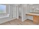 This bathroom boasts a soaking tub, a glass-enclosed shower, and a wood vanity with a large mirror at 6790 Gold Yarrow St, Las Vegas, NV 89148