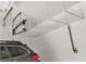 Car parked in a two-car garage with overhead storage and lighting, with a black ladder hanging from above at 6790 Gold Yarrow St, Las Vegas, NV 89148