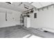 An empty two-car garage with white walls and a gray concrete floor with overhead storage and lighting at 6790 Gold Yarrow St, Las Vegas, NV 89148
