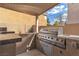 Outdoor built-in grill area with stainless steel grill, granite countertops and cabinets at 6790 Gold Yarrow St, Las Vegas, NV 89148