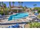 Community pool area with lounge chairs, a covered area and lush landscaping at 6790 Gold Yarrow St, Las Vegas, NV 89148