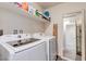 Laundry room with washer, dryer, shelf, and a decorative mirror at 6804 Surf Green Ct, North Las Vegas, NV 89086