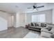 Spacious living room featuring a gray sectional sofa, ceiling fan, and ample natural light at 6804 Surf Green Ct, North Las Vegas, NV 89086
