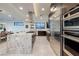 Spacious open kitchen boasts stainless steel appliances, a large island, and modern design with a view into the dining area at 794 Willits St, Las Vegas, NV 89138