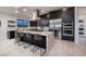 Modern kitchen with a large island with bar stool seating, stainless steel appliances, and dark cabinetry at 794 Willits St, Las Vegas, NV 89138