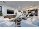 Modern living room featuring a large TV, stylish furniture, and seamless access to an open kitchen and dining area at 794 Willits St, Las Vegas, NV 89138