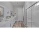 Bright bathroom featuring a glass shower, double sinks, and modern fixtures and plank wall at 12438 Heritage Bend Dr, Las Vegas, NV 89138