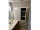 Bathroom vanity with wood cabinet and an open medicine cabinet, with neutral decor at 2541 Love St, Las Vegas, NV 89121