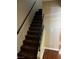 Carpeted stairway with dark railing, offering access to the next level of the home at 2541 Love St, Las Vegas, NV 89121