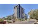 Modern high-rise building with expansive glass windows, multiple balconies, and lush landscaping in an urban setting at 353 E Bonneville Ave # 754, Las Vegas, NV 89101