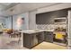 Open-concept kitchen with stainless steel appliances, gray cabinetry, tile backsplash, and a breakfast bar overlooking the living area at 353 E Bonneville Ave # 754, Las Vegas, NV 89101
