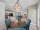 Open-concept living space with a dining area featuring a modern chandelier, connected to the kitchen and living room at 496 Grassrange Ln, Henderson, NV 89052