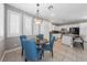 Dining area is open to a kitchen with white cabinets and stainless steel appliances at 496 Grassrange Ln, Henderson, NV 89052