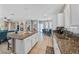Showcases a spacious kitchen with granite counters, stainless steel appliances, an island with seating, and adjacent living spaces at 496 Grassrange Ln, Henderson, NV 89052