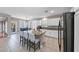 Showcases a kitchen with granite counters, stainless steel appliances, a kitchen island with seating, and an adjacent dining area at 496 Grassrange Ln, Henderson, NV 89052