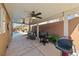 Covered patio featuring ceiling fans, grills, and an outdoor seating area, perfect for entertaining at 496 Grassrange Ln, Henderson, NV 89052