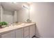 Bright bathroom with double sinks, vanity, and a large mirror with decorative lights at 50 E Serene Ave # 107, Las Vegas, NV 89123