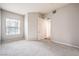 Neutral bedroom with carpet, a large window, and a closet door slightly ajar at 50 E Serene Ave # 107, Las Vegas, NV 89123
