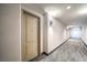 Well-lit hallway with neutral decor and modern carpet leading to apartment entrance at 50 E Serene Ave # 107, Las Vegas, NV 89123