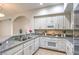 Well-designed kitchen features white cabinets, granite counters and modern appliances at 50 E Serene Ave # 107, Las Vegas, NV 89123