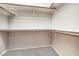 A walk-in closet with carpeted floor and multiple shelves and wooden bars for clothes at 50 E Serene Ave # 107, Las Vegas, NV 89123