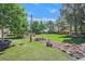Lush backyard showcasing an American flag, mature trees, and rock landscaping, perfect for outdoor entertaining and leisure at 8208 Flowing Rapids Ct, Las Vegas, NV 89131