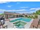Spacious backyard with a pool, jacuzzi, a covered patio, and lush landscaping at 8208 Flowing Rapids Ct, Las Vegas, NV 89131