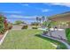 A backyard featuring a well-maintained lawn, plants, trees and a partially covered pool at 8208 Flowing Rapids Ct, Las Vegas, NV 89131